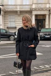 a lady wears a black tencel wool double-faced coat with belt